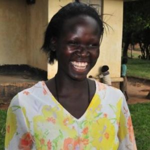 A domestic violence survivor who is a beneficiary of one of MIFUMI's economic empowerment group's smiling at the camera