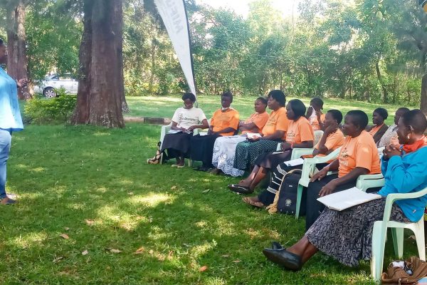 a group of women sitting on chairs in a park